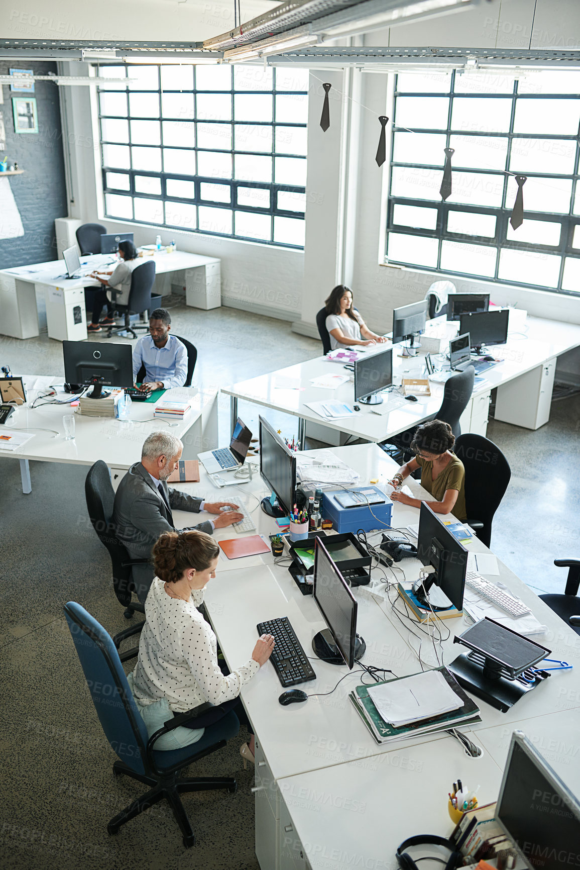 Buy stock photo Shot of a group of coworkers sitting at their workstations in an office