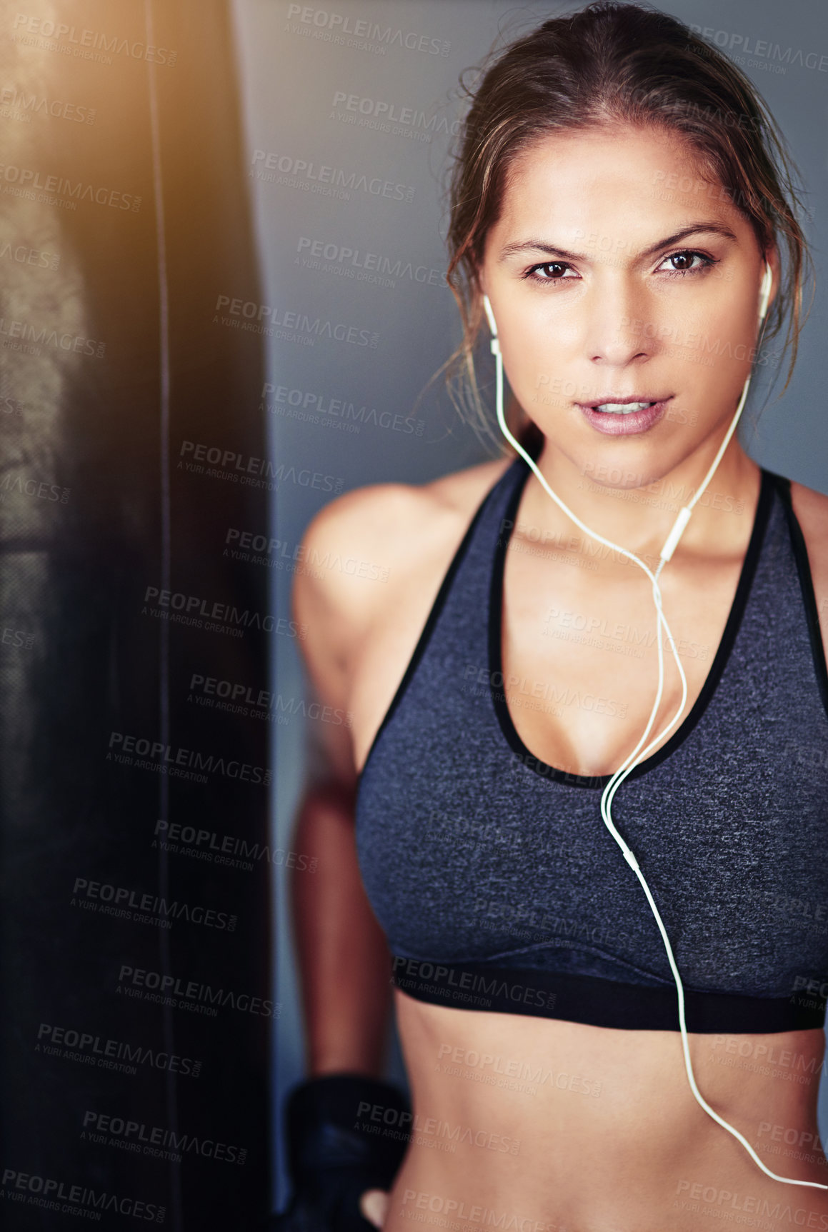 Buy stock photo Portrait, woman and boxer with workout, punching bag or exercise for wellness or challenge grey background. Earphones, athlete or healthy girl in gym, fitness or audio with energy or listen to music