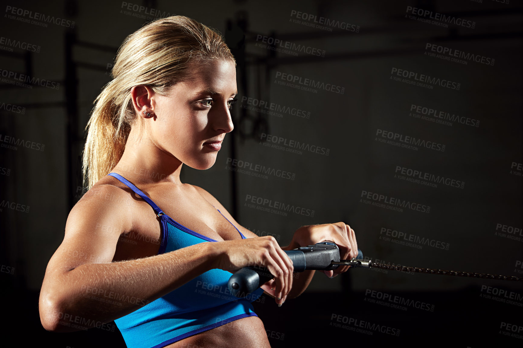 Buy stock photo Shot of a young woman working out on a rowing machine