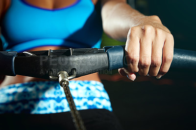 Buy stock photo Cropped shot of a young woman working out on a rowing machine