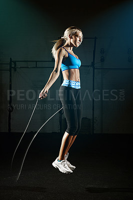 Buy stock photo Woman, jumping rope and fitness in gym, energy and action with healthy active person. Young female athlete, exercise with performance and cardio workout for health with sports in gymnasium