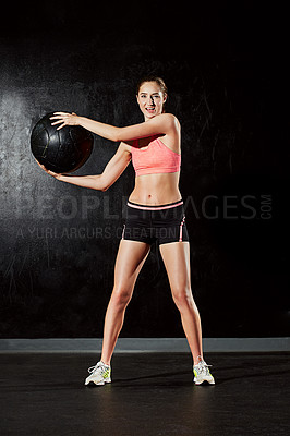 Buy stock photo Portrait of a young woman working out with a medicine ball in the studio