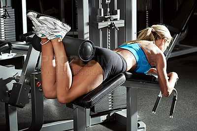 Buy stock photo Shot of a young woman using an exercise machine at the gym