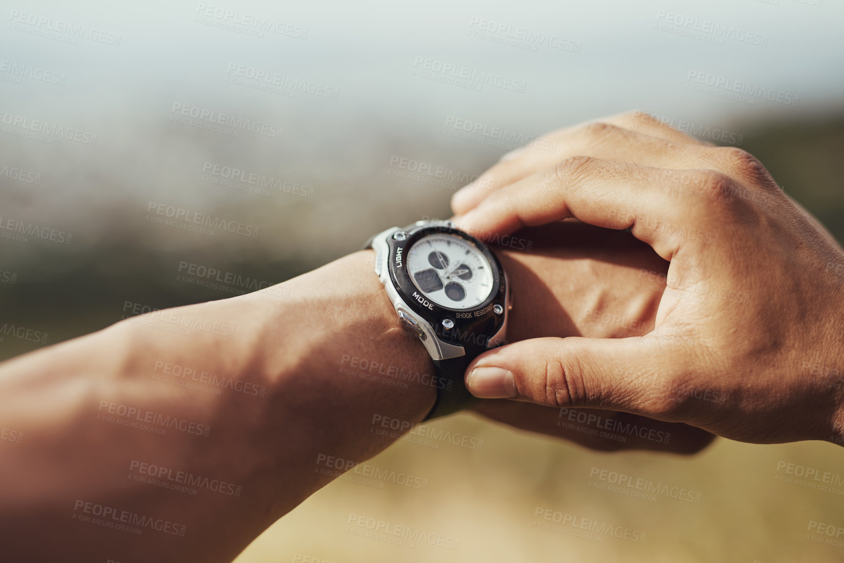 Buy stock photo Cropped shot of a runner checking his sports watch while training