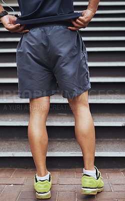 Buy stock photo Cropped shot of a male runner standing at the bottom of a staircase
