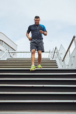 Buy stock photo Fitness, running and man on steps in city with health, wellness and earphones for streaming. Urban workout, body care and runner listening to music, podcast or app on stairs for morning exercise.