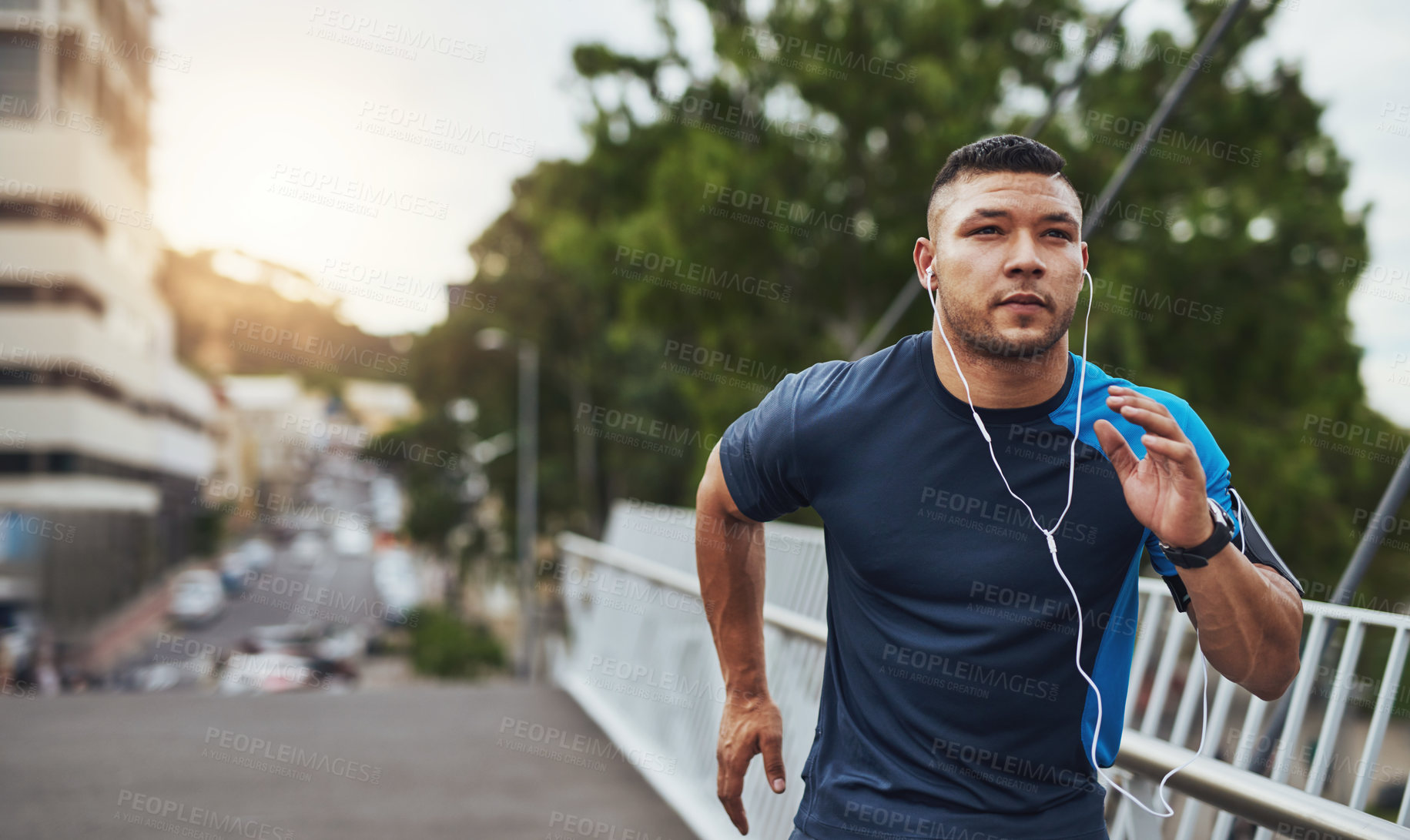 Buy stock photo Shot of a young man out for a run in the city