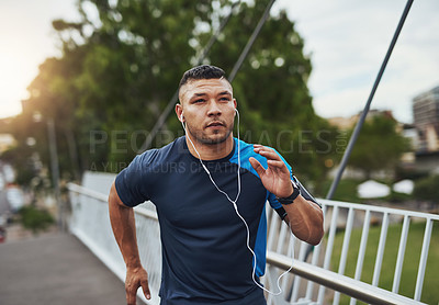 Buy stock photo Shot of a young man out for a run in the city