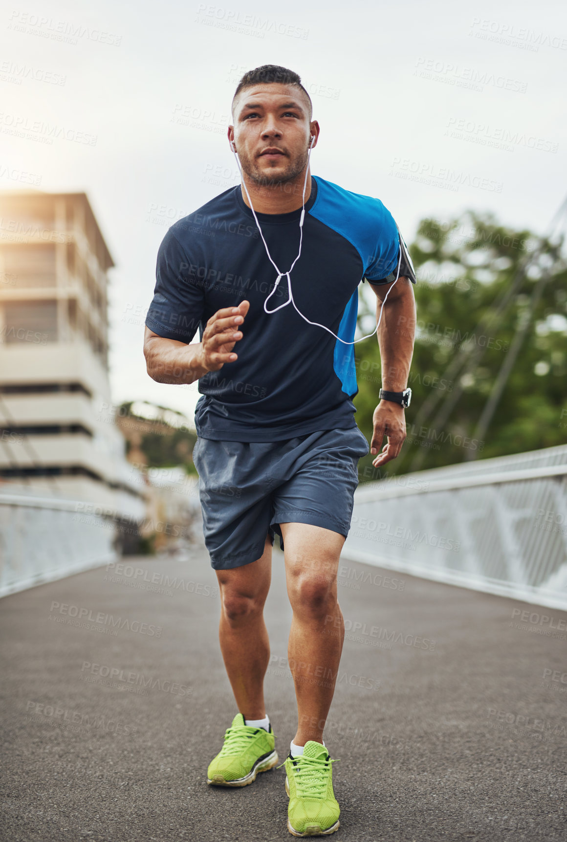 Buy stock photo Shot of a young man out for a run in the city