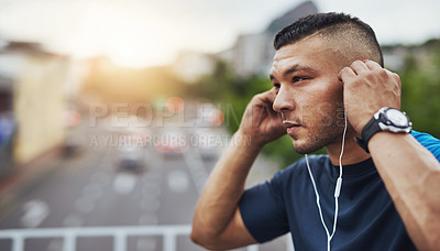 Buy stock photo Shot of a young man out for a run in the city