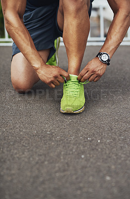 Buy stock photo Cropped shot of a man tying his shoelaces before a run
