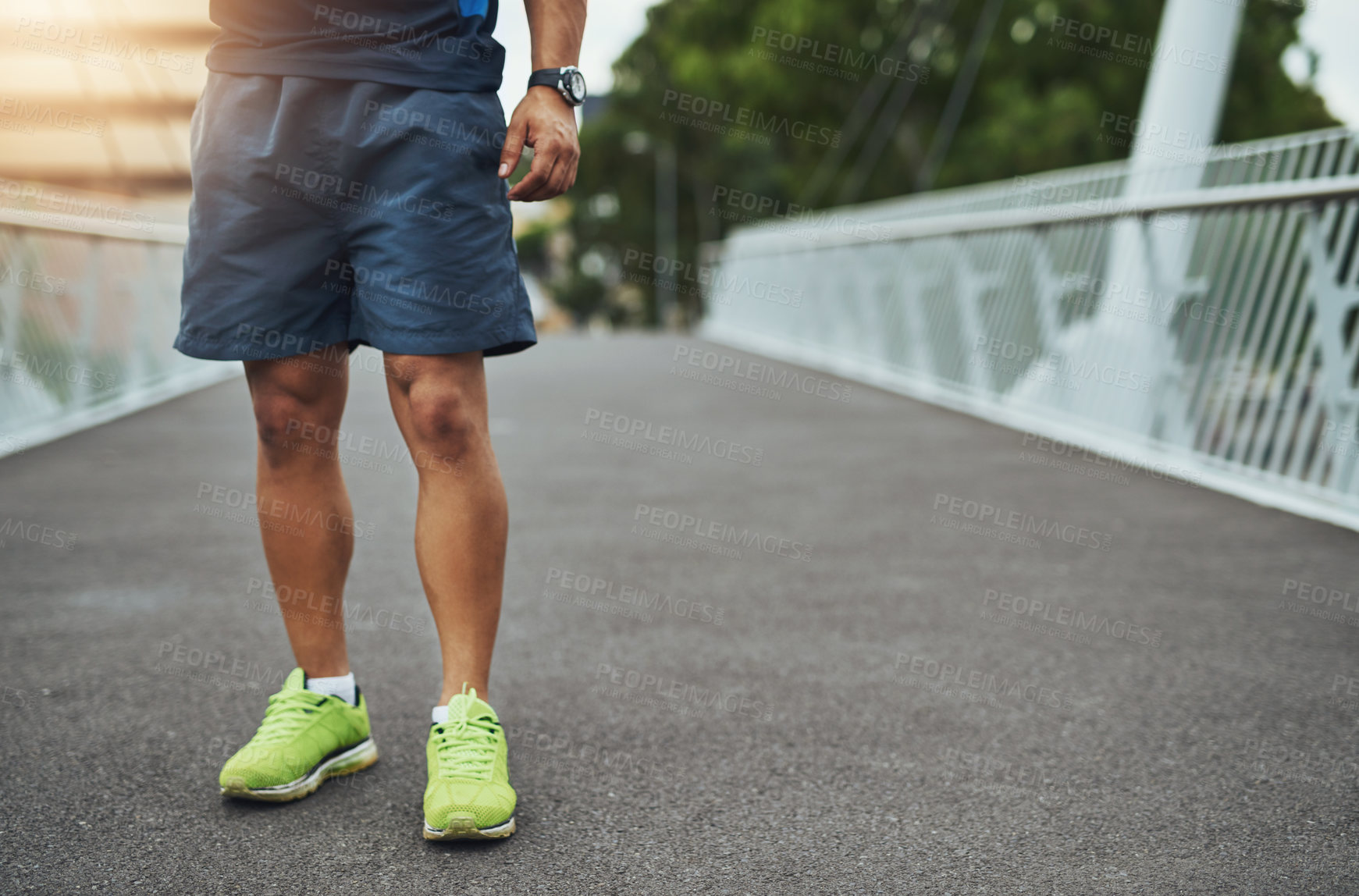 Buy stock photo Running, fitness and legs of man in city for exercise, marathon training and cardio workout outdoors. Sports, health and feet of person on bridge for wellbeing, wellness and warm up in urban town