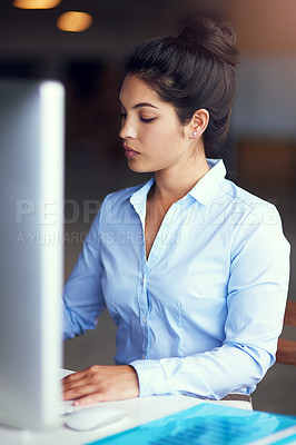 Buy stock photo Shot of a young businesswoman working on her office computer