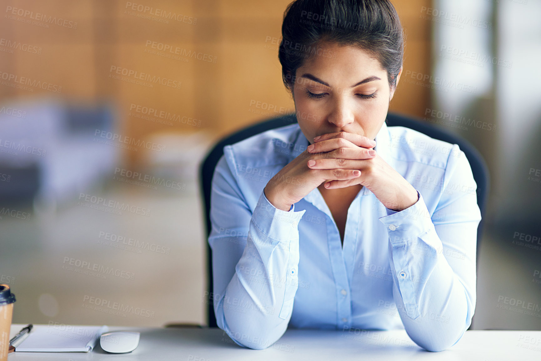 Buy stock photo Shot of a young businesswoman looking stressed while sitting at her desk