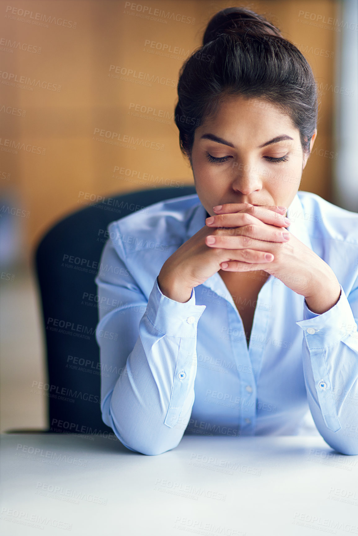 Buy stock photo Shot of a young businesswoman looking stressed while sitting at her desk