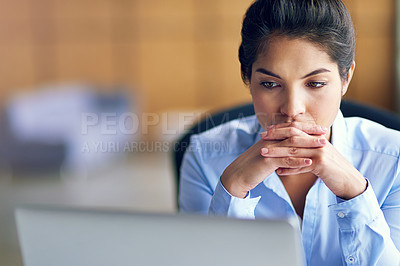 Buy stock photo Shot of a young businesswoman looking stressed while working on her laptop