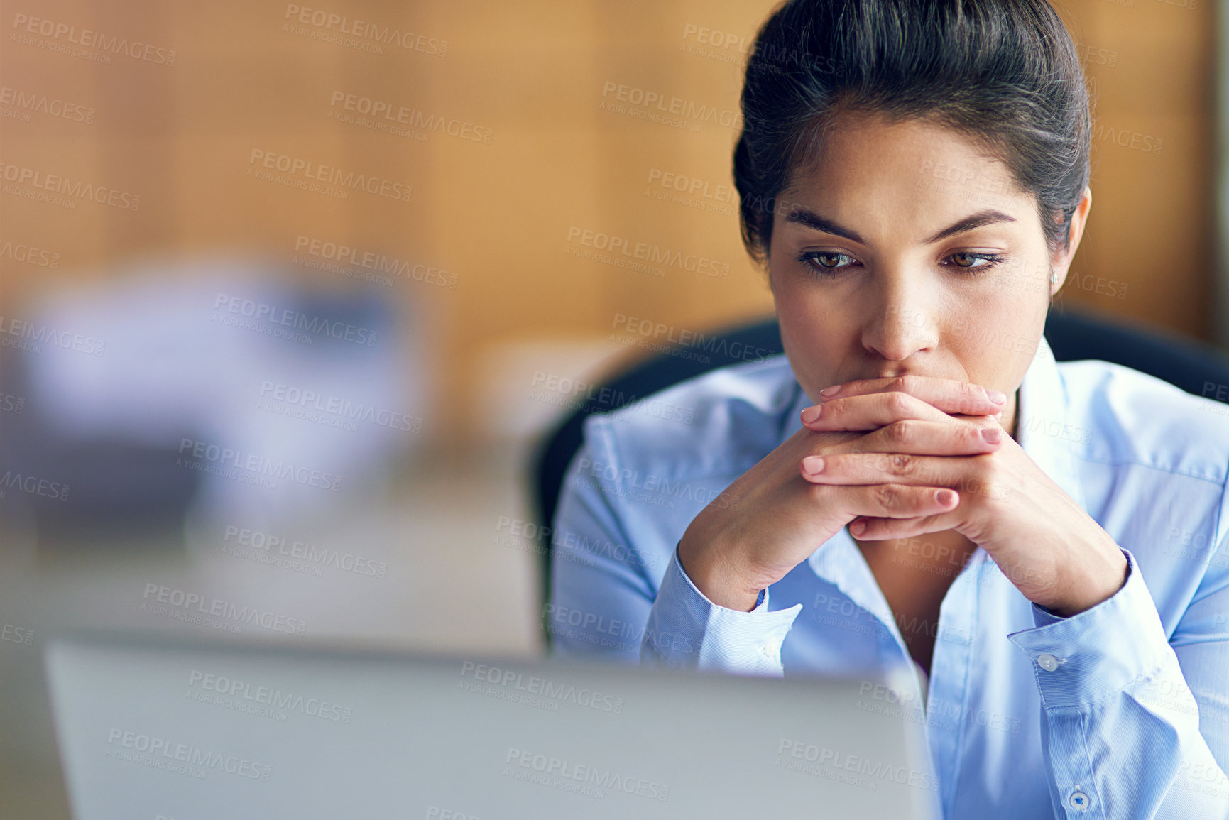 Buy stock photo Shot of a young businesswoman looking stressed while working on her laptop