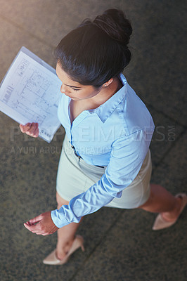 Buy stock photo High angle shot of a confident young businesswoman walking across an office floor