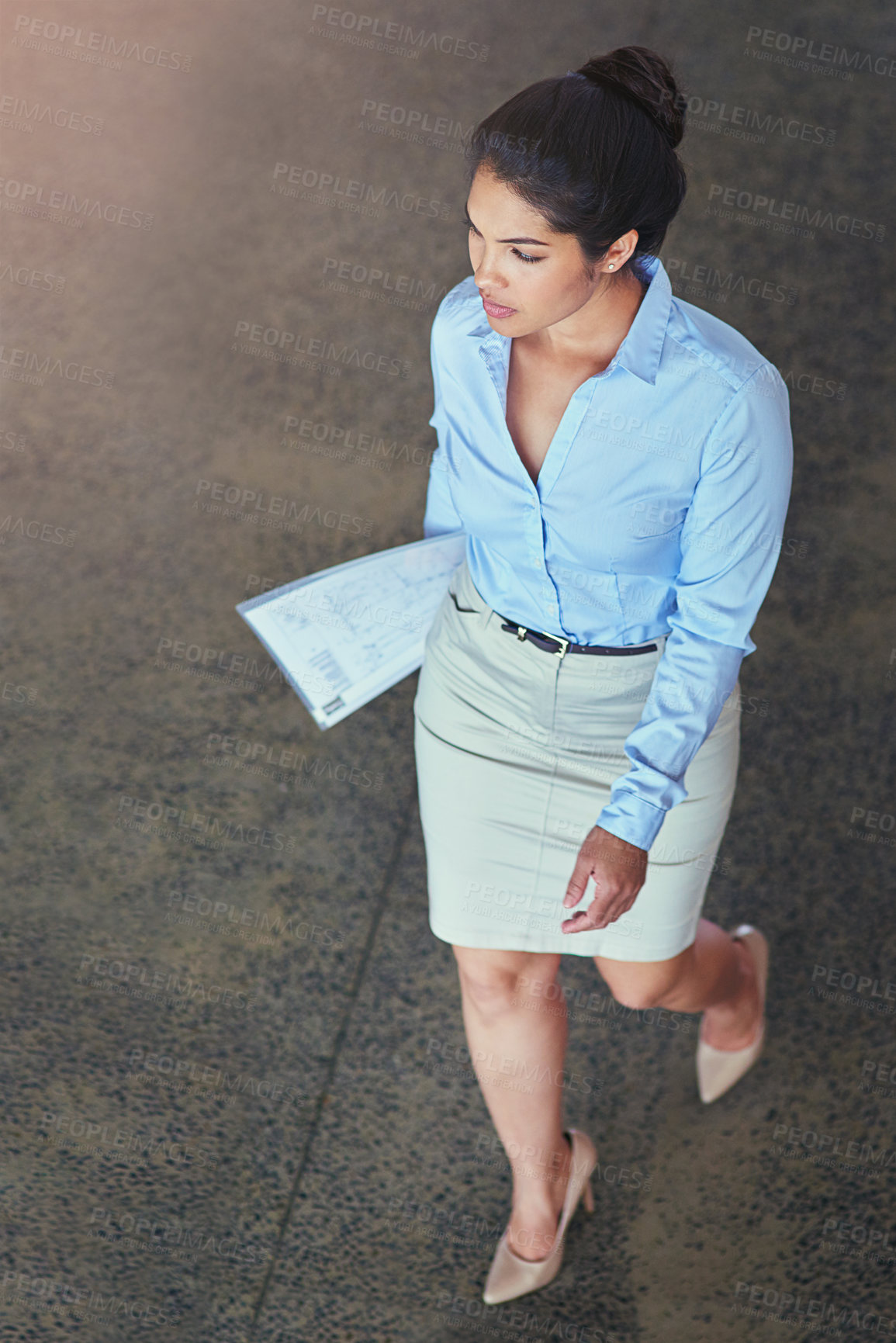 Buy stock photo High angle shot of a confident young businesswoman walking across an office floor