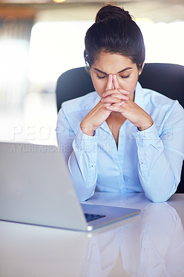 Buy stock photo Shot of a young businesswoman looking stressed while sitting at her desk