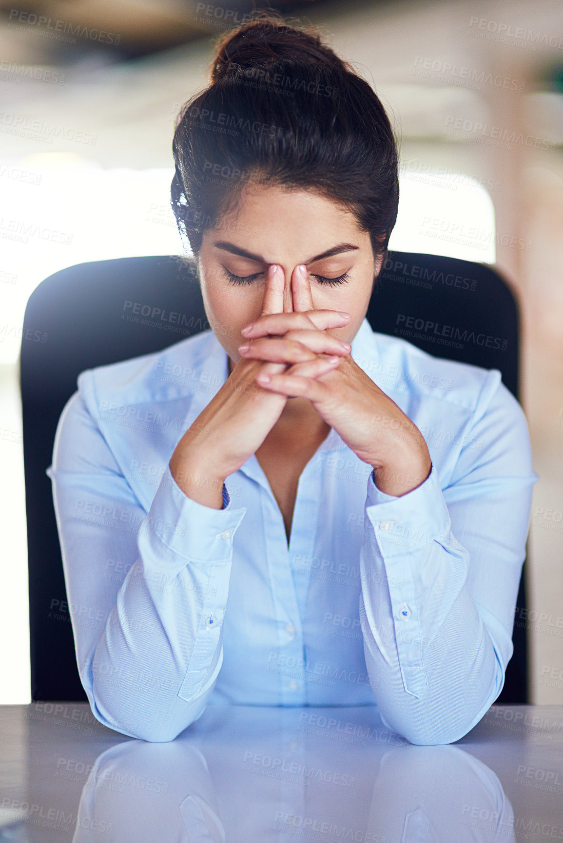 Buy stock photo Shot of a young businesswoman looking stressed while sitting at her desk