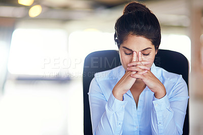 Buy stock photo Shot of a young businesswoman looking stressed while sitting in her office chair