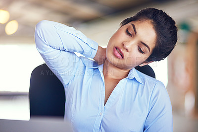 Buy stock photo Shot of a young businesswoman suffering from neck pain while sitting at her desk