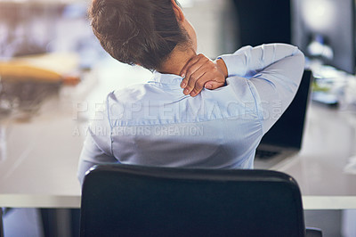 Buy stock photo Rearview shot of a businesswoman suffering from neck pain while sitting at her desk