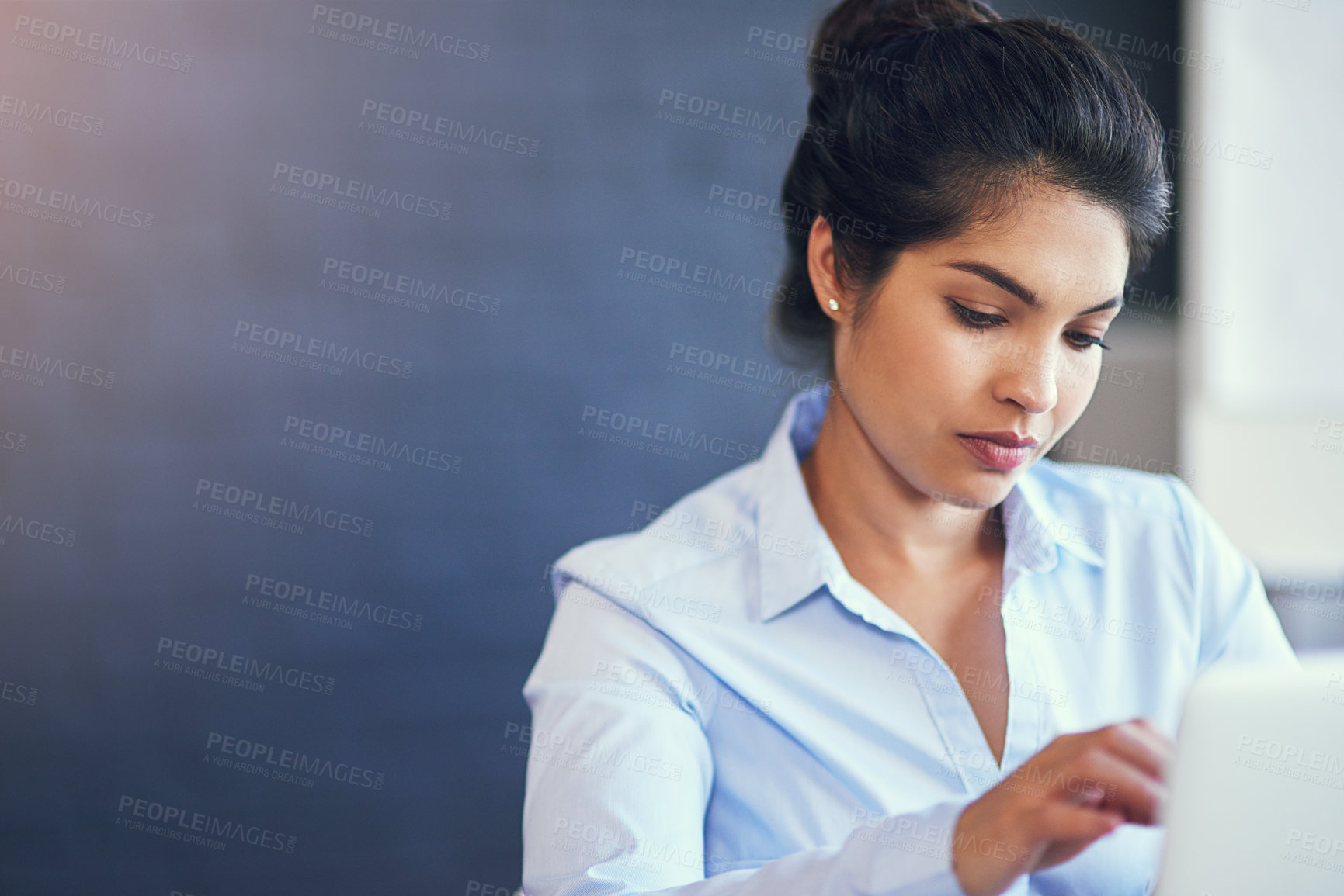 Buy stock photo Cropped shot of a young businesswoman using her laptop in the office