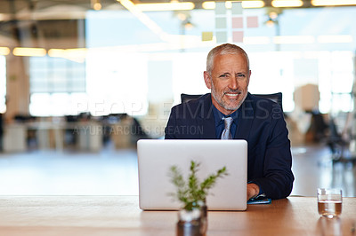 Buy stock photo Cropped portrait of a mature businessman using a laptop in an office
