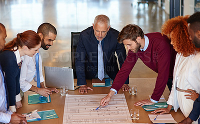 Buy stock photo Shot of a group of businesspeople discussing documents in a meeting