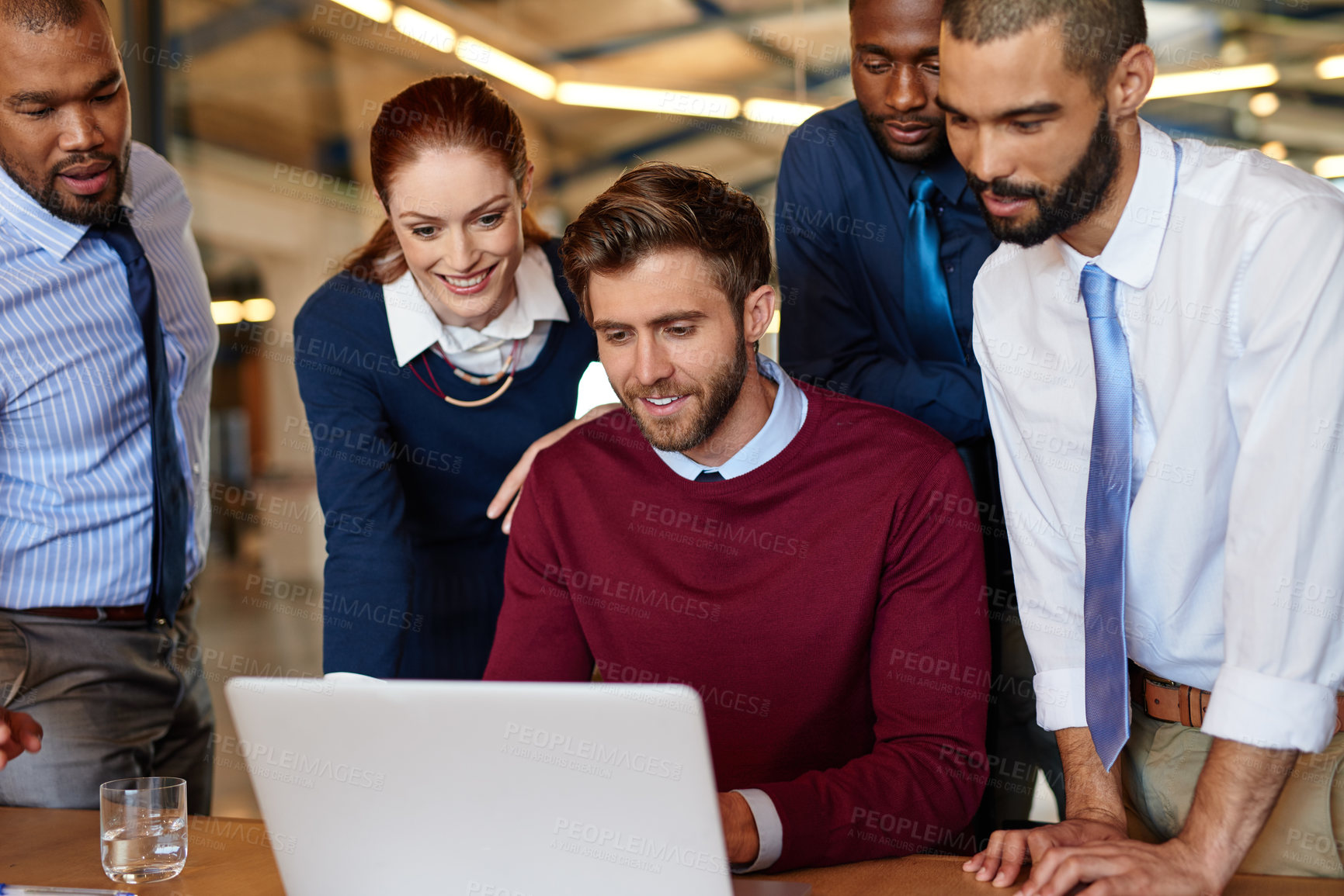 Buy stock photo Shot of a group of businesspeople working together at a laptop