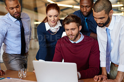 Buy stock photo Shot of a group of businesspeople working together at a laptop