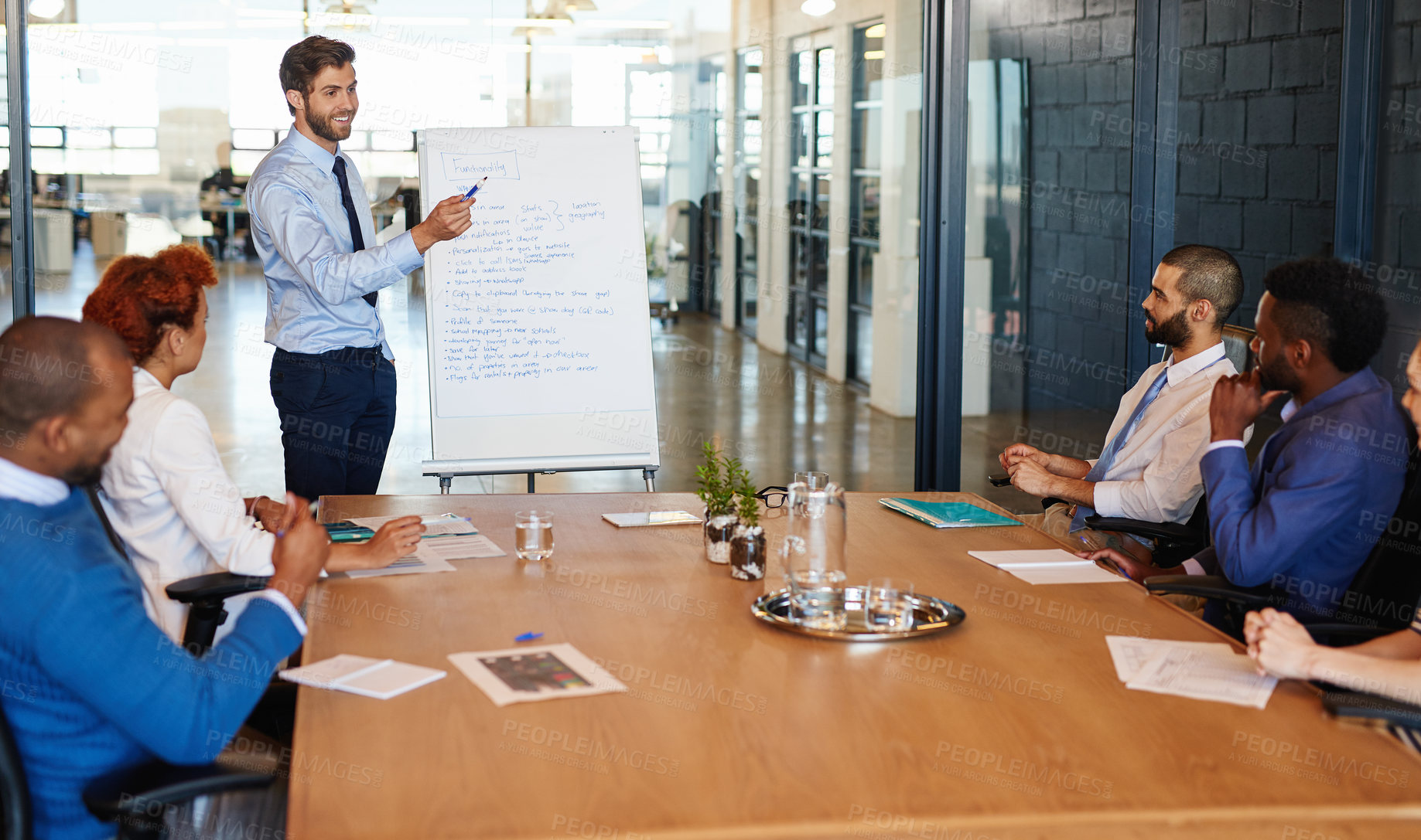 Buy stock photo Businessman, presentation and meeting with team on whiteboard for brainstorming, mission or plan at office. Young man, speaker or spokesperson talking to group of employees for company productivity