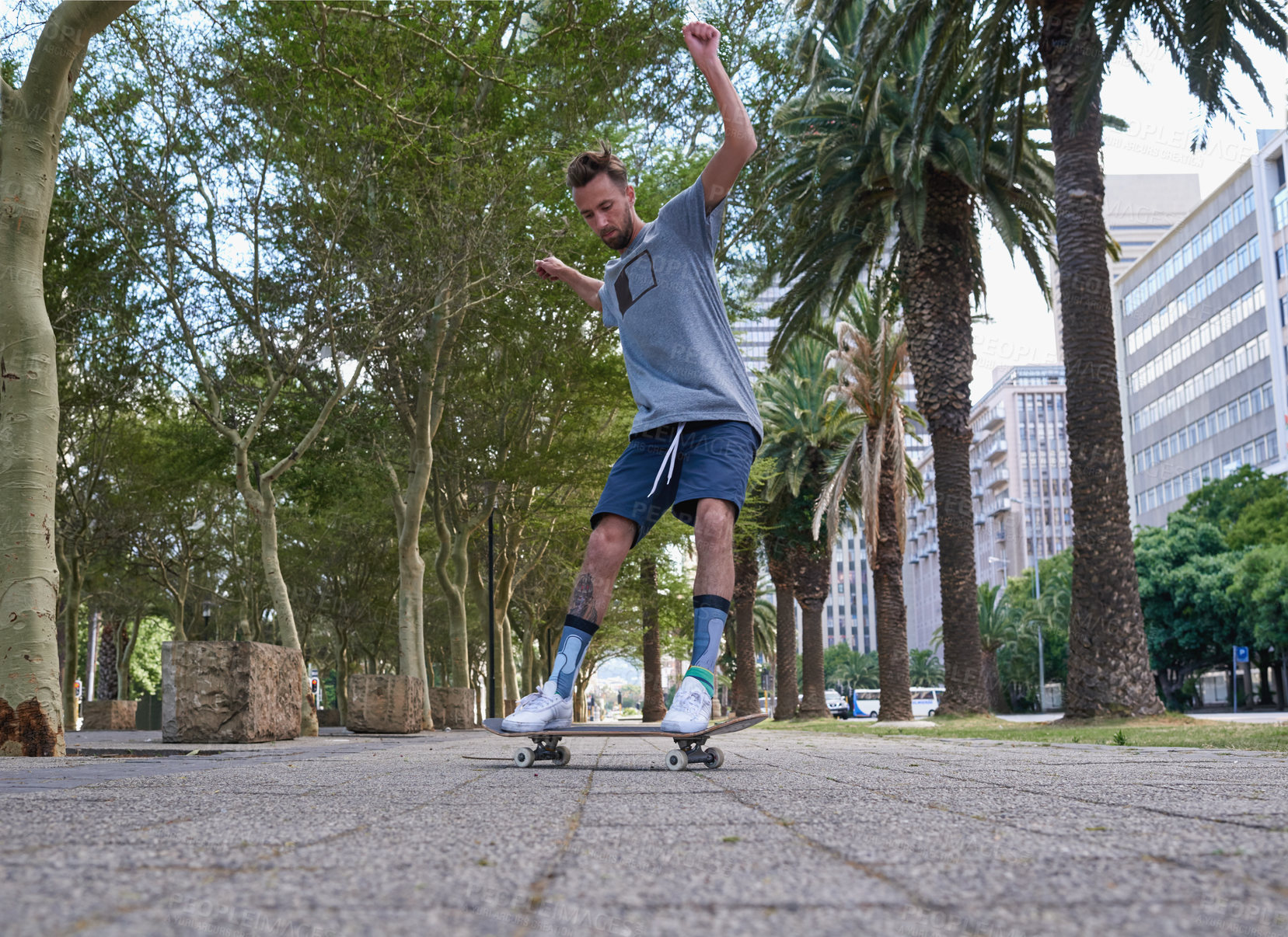 Buy stock photo Shot of a young man skateboarding through the city