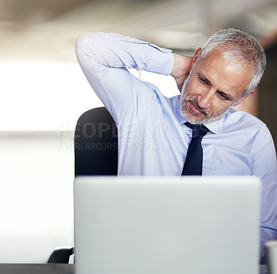 Buy stock photo Cropped shot of a mature businessman looking stressed while working in his office
