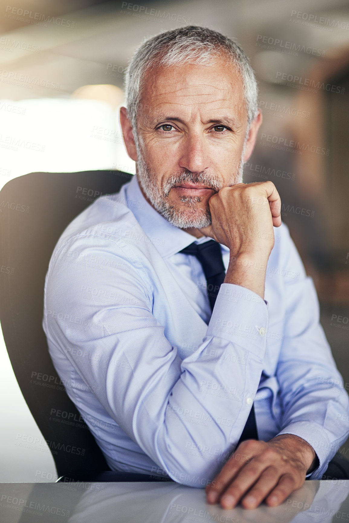 Buy stock photo Cropped portrait of a mature businessman sitting in his office