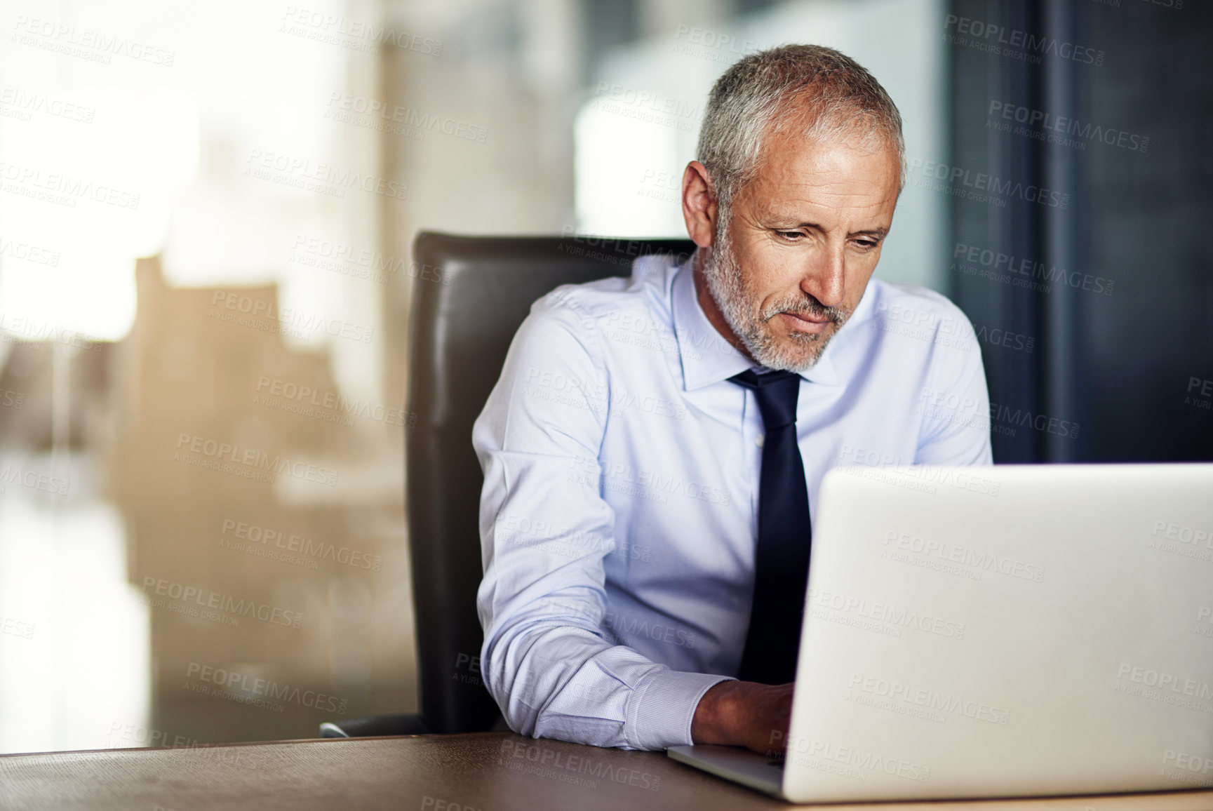 Buy stock photo Cropped shot of a mature businessman working in his office