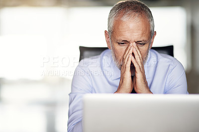 Buy stock photo Cropped shot of a mature businessman looking stressed while working in his office