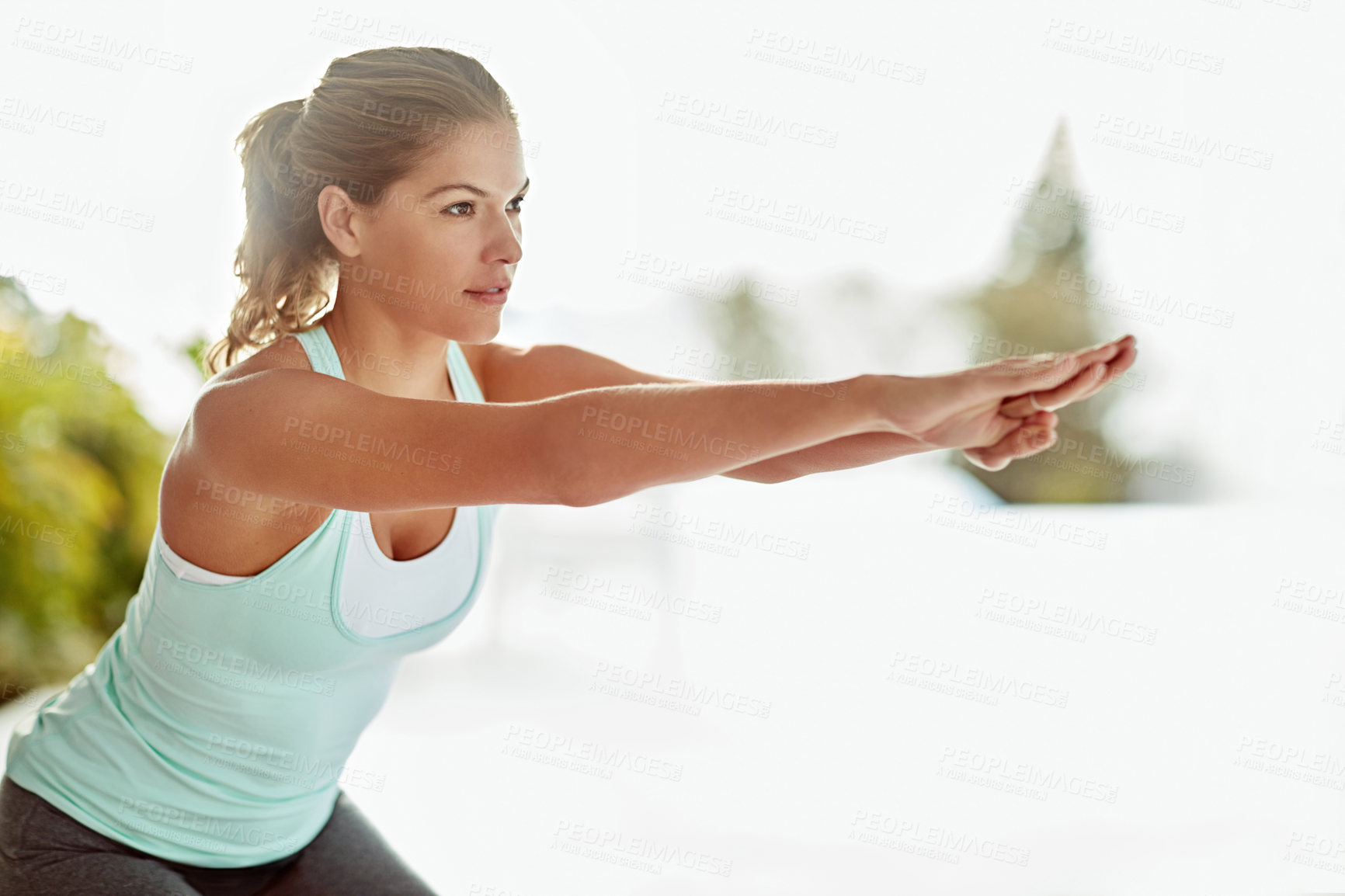 Buy stock photo Shot of a young woman doing squats during a workout