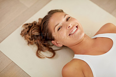 Buy stock photo Cropped portrait of a sporty young woman lying on an exercise mat