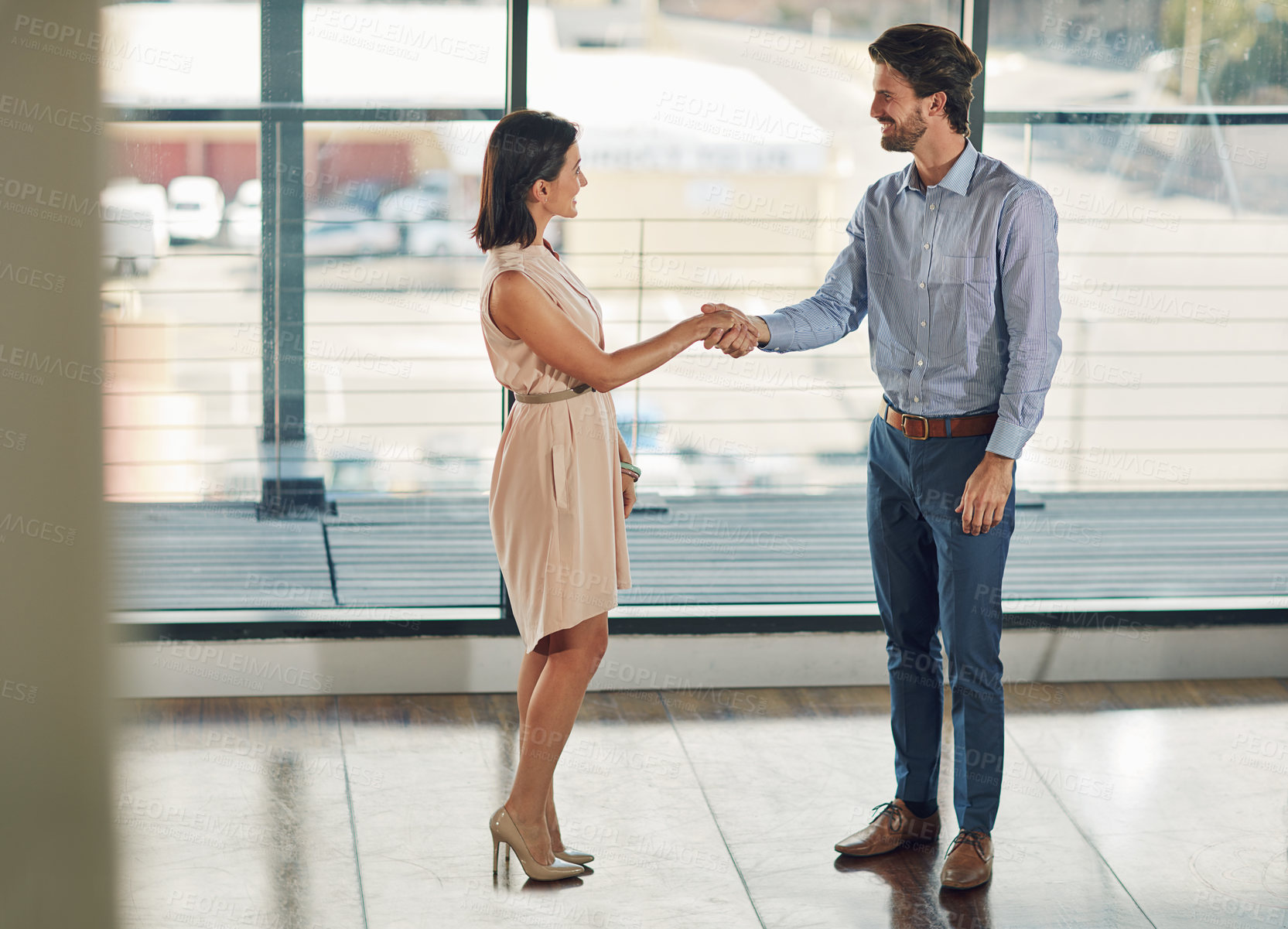 Buy stock photo Full length shot of two businesspeople shaking hands in the office