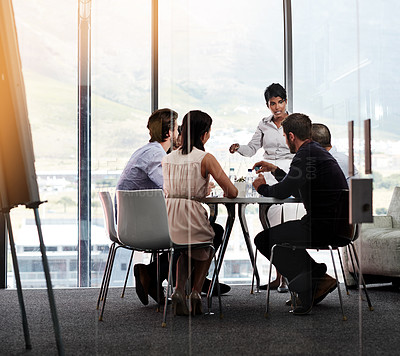 Buy stock photo Shot of a businesswoman giving a presentation to a group of colleagues in a boardroom
