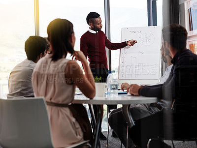 Buy stock photo Shot of a businessman giving a whiteboard presentation to a group of colleagues in a boardroom