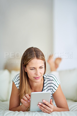 Buy stock photo Shot of a young woman browsing the internet at home 