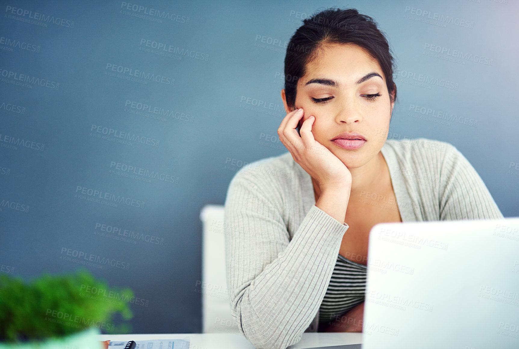 Buy stock photo Shot of a businesswoman looking bored at her desk