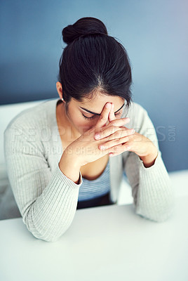 Buy stock photo Shot of a businesswoman looking stressed at her desk