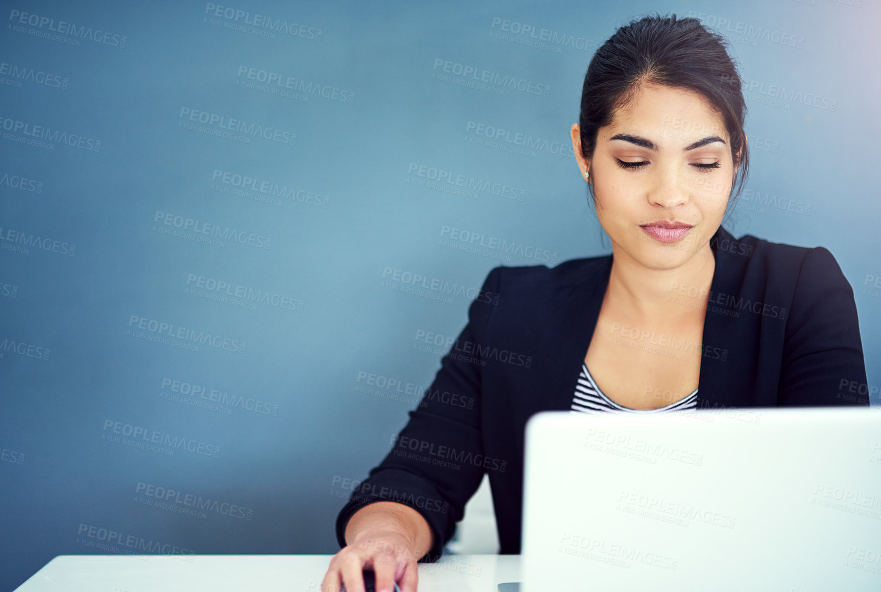 Buy stock photo Shot of a young businesswoman working at her desk