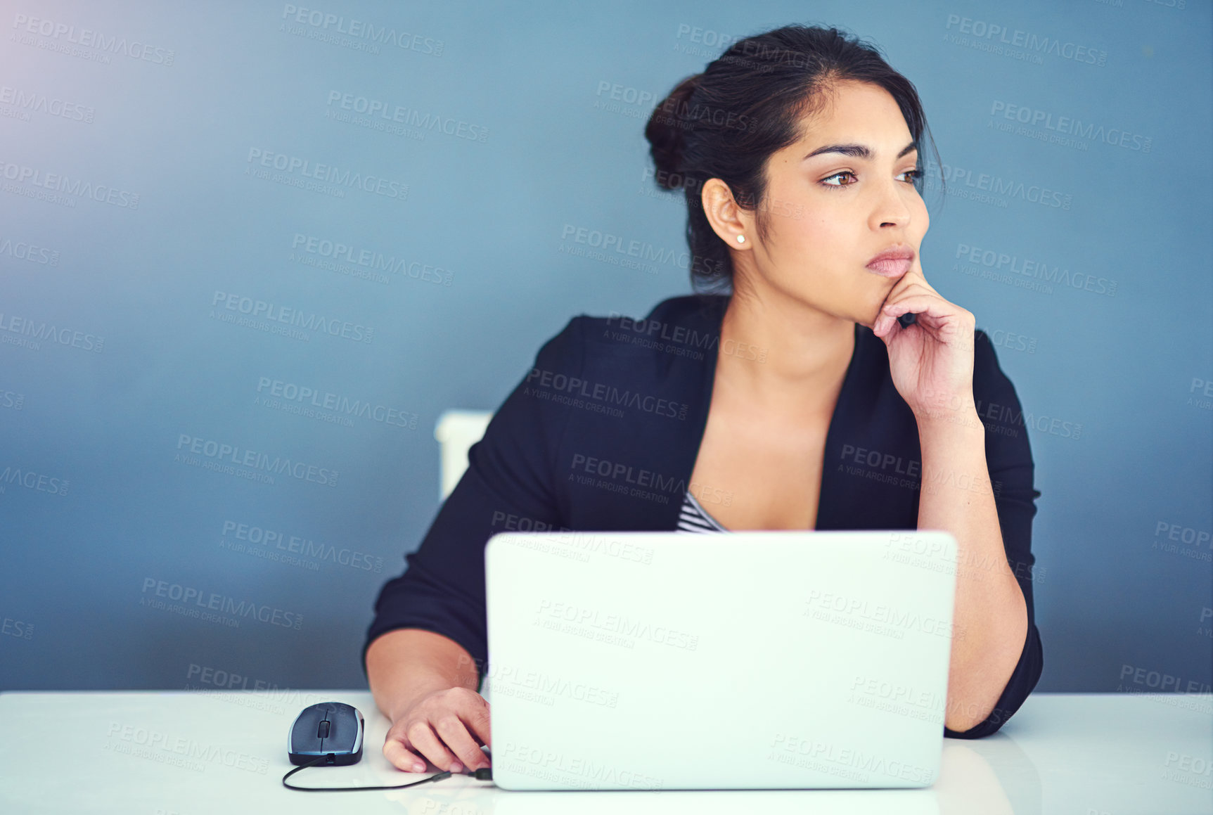 Buy stock photo Cropped shot of a young businesswoman looking distracted at her desk