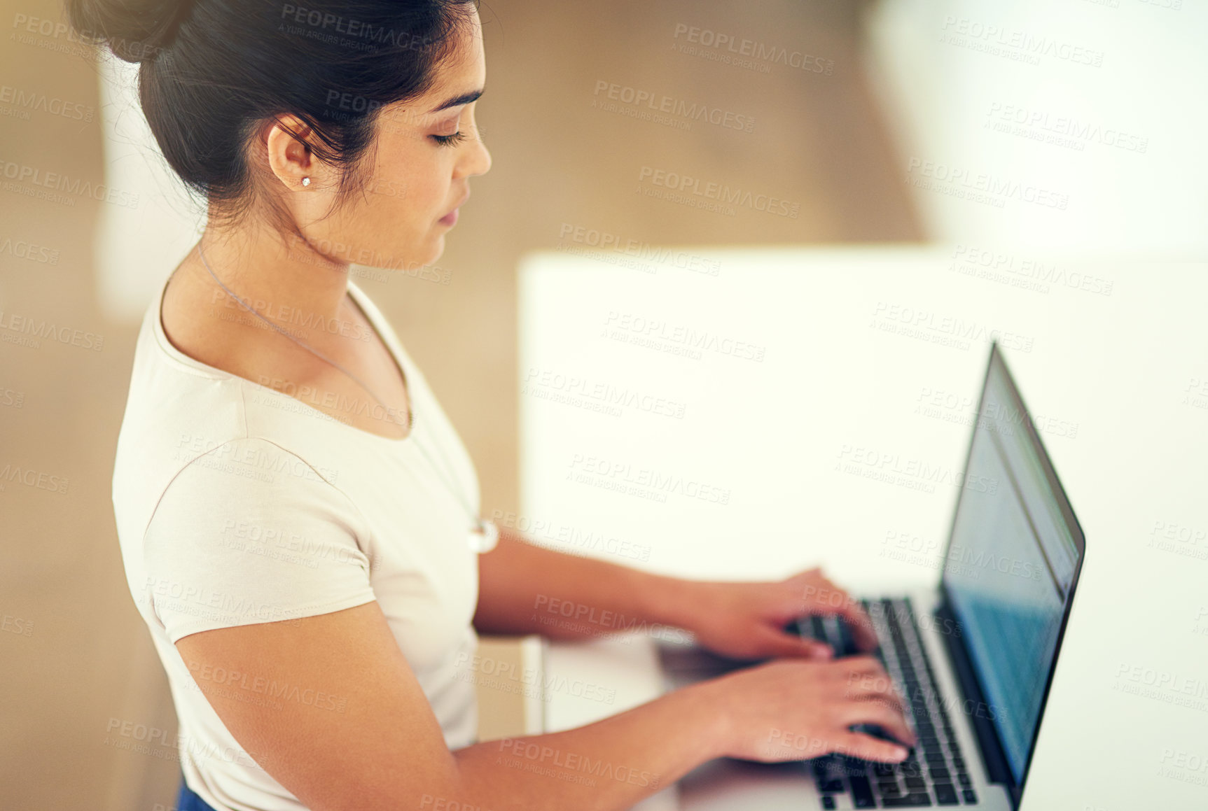 Buy stock photo Cropped shot of a young businesswoman working on her laptop at home